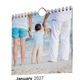 Close-up of a personalised photo kitchen calendar with wire binding and an integrated hanging hook.