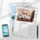 Two A4 photo calendars for 2025,  The front calendar features your own image. A smartphone and pen are placed next to the calendars on a white desk, with space for notes in the month grids.