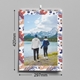 Wall calendar featuring a scenic photo of a couple holding hands by a mountain lake, framed with a colourful leaf pattern. Dimensions are clearly shown as 297mm in height and 210mm in width (A4 size). A metal wire binding and hanging hook are visible at the top, highlighting the calendar's practical design for easy wall display.