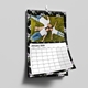 Floral-themed wall calendar for January 2026 featuring a photo of a family lying on grass, smiling and dressed in white and denim. The calendar is wire bound with a white hook for hanging and displayed against a plain wall. The date grid is clean and spacious, bordered by a black background with light purple flowers.