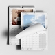 Two A3 wall calendars with marble designs. One displays a Christmas-themed family photo for December, and the other shows a landscape image of the sky with a page being turned. Both calendars feature monthly grids and spiral bindings with hanging hooks.