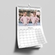 Personalised marble-effect A3 wall calendar hanging by its wire-bound hook with a large family photo.