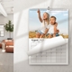 Personalised photo wall calendar hanging in a home with a monthly date grid