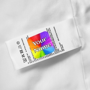 A colourful personalised name label with a rainbow design reading Your Name is attached to a white garment care tag. The label is firmly applied, demonstrating its use for easily identifying clothing items.