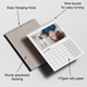 Wall calendar open to May 2026, featuring a mother lying on a bed with her baby. Annotations highlight product details: easy hanging hook, wire binding for smooth page turning, 170gsm silk paper, and sturdy greyboard backing. The calendar has a clean grid layout and a soft, high-quality finish.