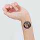 Close-up of a wrist with a circular black temporary tattoo reading Hen Party Brighton 2023, featuring a smiling woman's face in the centre. The tattoo stands out against the skin, creating a fun, personalised touch.