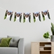 Personalised photo bunting with a child being held up by an adult, displayed in a stylish living room with a grey sofa and plants.