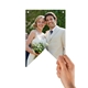 A hand holding a single personalised bunting flag, featuring a newlywed couple smiling at the camera with greenery in the background.