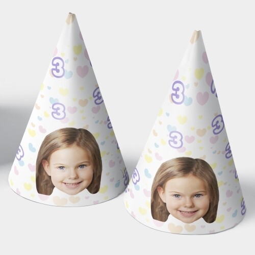 Two customised party hats with a white background, personalised with your photo and number of your choice. The hats are displayed upright side by side. Perfect for birthdays or celebrations.