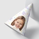 Customised party hat, the number a number of your choice,personalised with your photo. The hat is propped against a smooth white surface. Ideal for birthdays or celebrations.