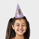 Smiling girl wearing a customised party hat with your own face and number. The girl has pigtails and is laughing, showcasing the fun design. Ideal for birthdays or themed celebrations.