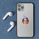 Personalised vinyl sticker of a smiling man wearing a blue party hat with the number 30, placed on the back of a silver smartphone. The phone rests on a textured blue surface beside wireless earbuds, perfect for customised birthday tech accessories.