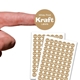 A small round personalised Kraft label with white print shown on a fingertip above two sheets filled with identical custom stickers. The brown labels have a striped texture and bold white text reading White Print Kraft Labels, ideal for crafts, packaging or branding.