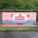 Custom vinyl banner used for bakery business advertising displayed on outdoor fence