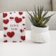 a6 valentines greeting card with love hearts next to a aloe vera plant