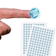 Transparent custom circle label sticker with a blue and white logo, shown on a fingertip, alongside two sheets filled with multiple identical stickers. Ideal for personalised branding or product labelling.