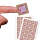 Two sheets of kraft Square label stickers with a custom pink and white logo, made from real kraft paper. The sheets display multiple eco-friendly labels, ideal for personalised branding or packaging.