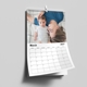Personalised A4 wall calendar hanging on a wall with a family photograph and monthly date grid